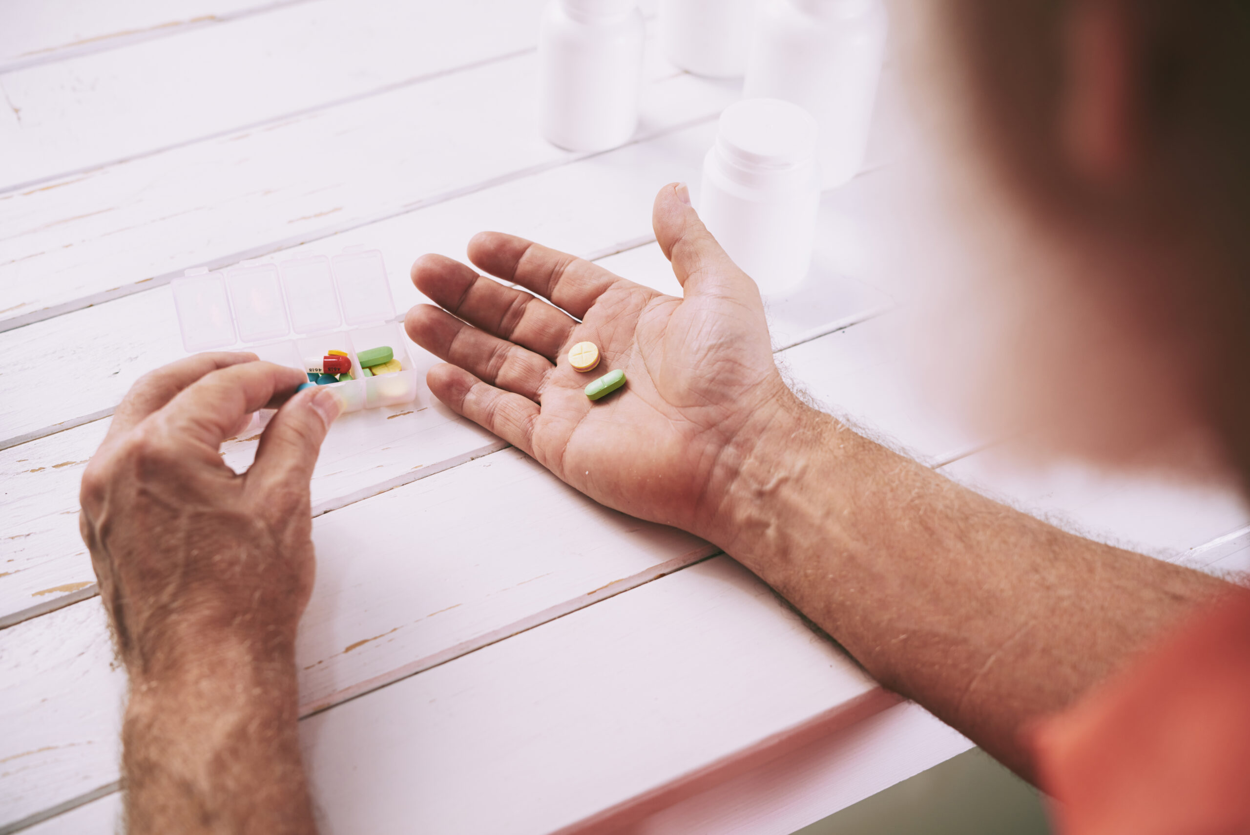 Aged man taking painkillers - Revenue Management Labs